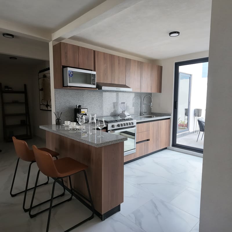 Cocina integral con barra desayunadora en casa muestra Creta Planta Baja, Pachuca