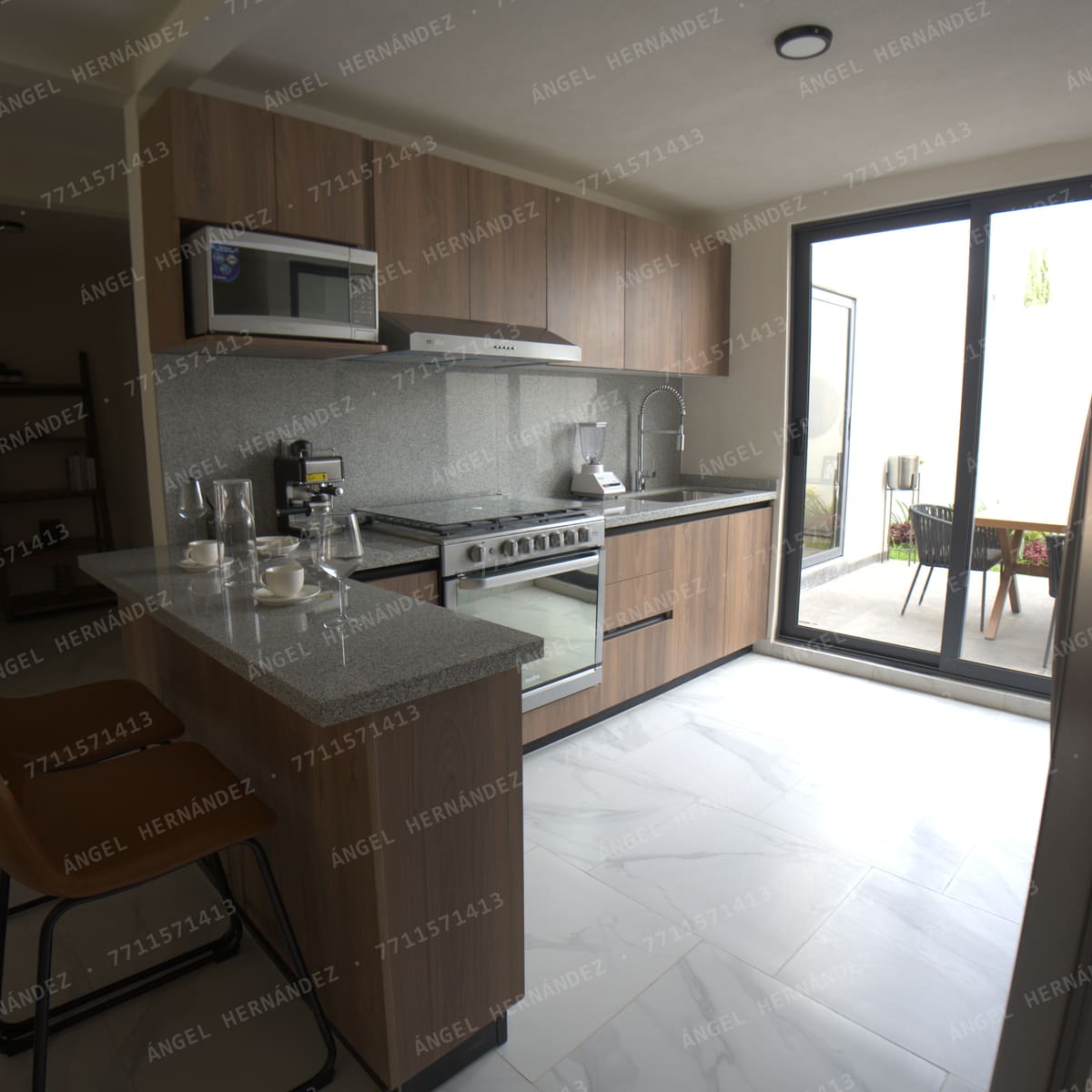 Cocina con barra y puerta de cristal a la terraza trasera en Creta Planta Baja, Basalto