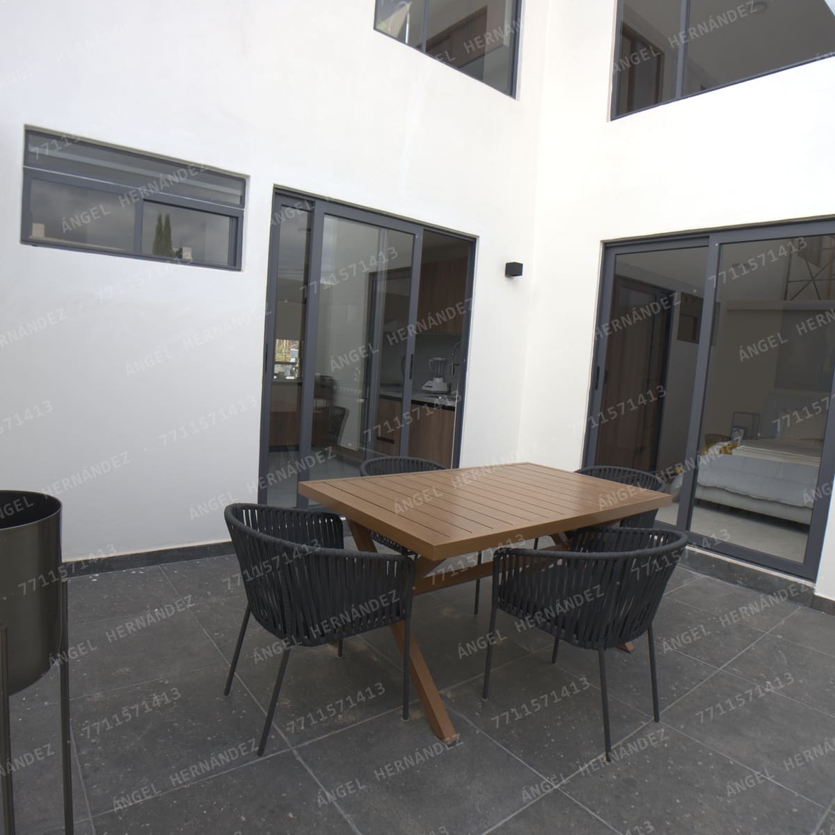 Terraza trasera con piso de piedra, con acceso desde la cocina y la segunda recámara en Creta Planta Baja, Basalto