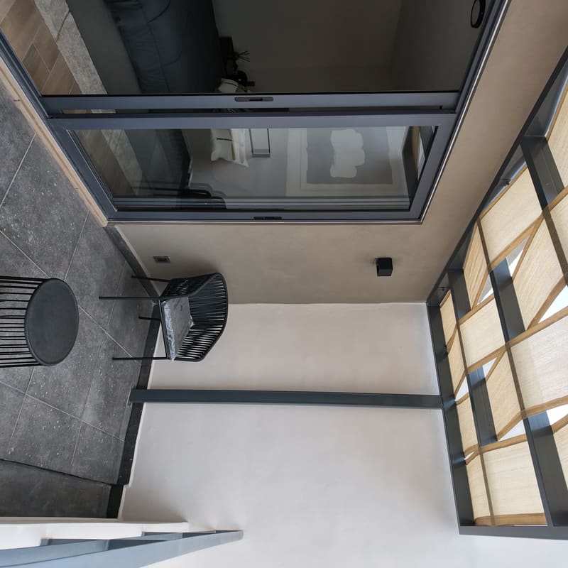 Terraza con pérgola conectada a recámara en modelo Recinto, Basalto