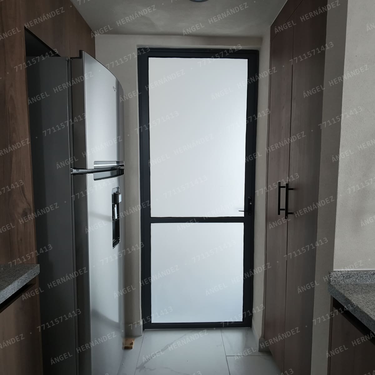 Cocina con puerta de cristal esmerilado al patio de servicio en casa muestra Recinto, Basalto