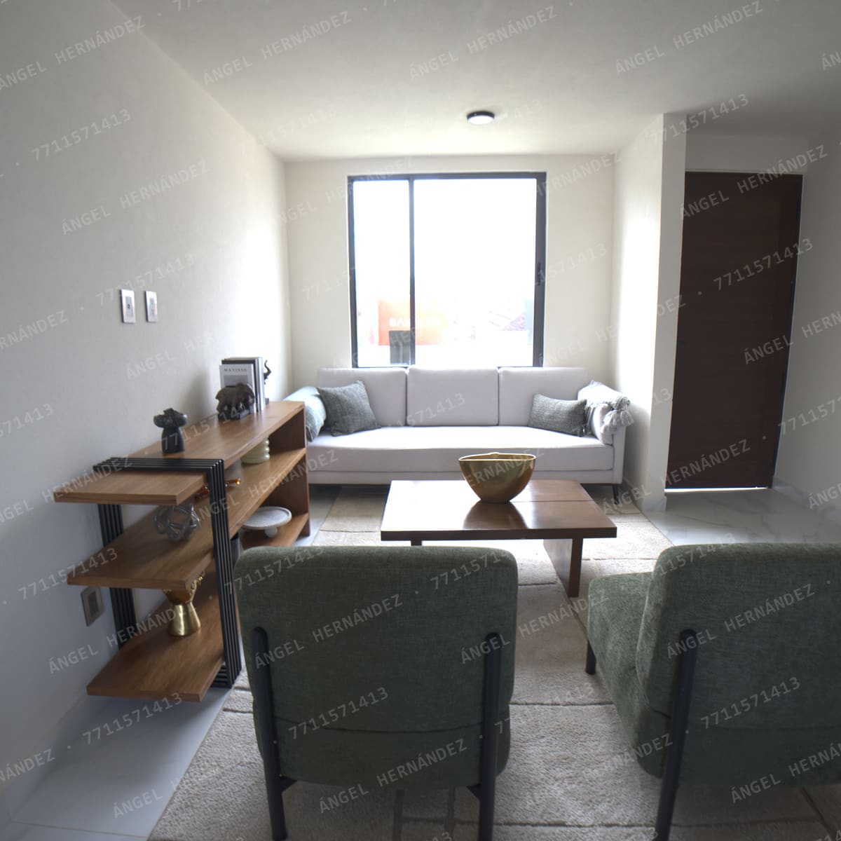 Sala con sofá y dos sillones hacia el ventanal en casa muestra Recinto, Basalto
