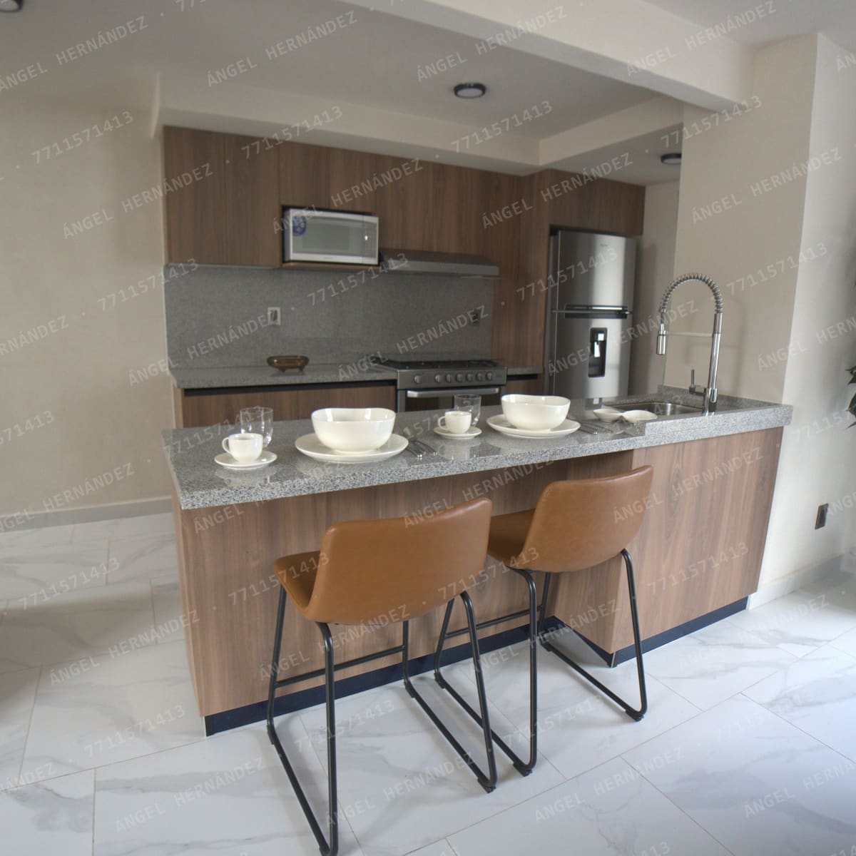 Cocina con barra de granito y bancos altos en casa muestra Recinto, Basalto