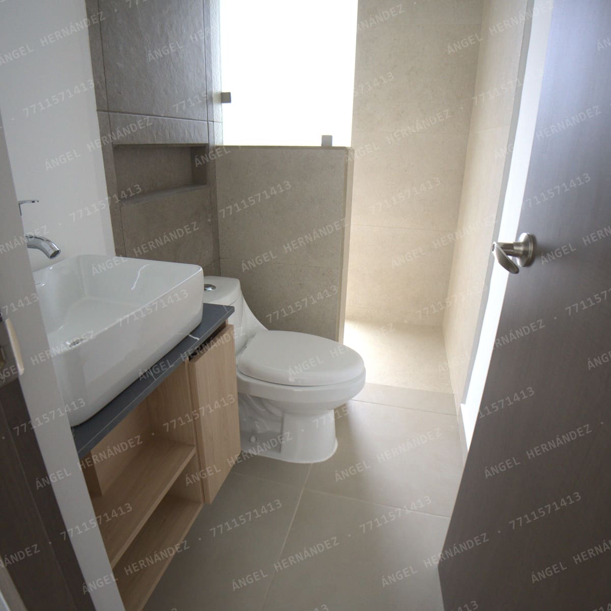 Baño de planta alta con lavabo de sobreponer y muros de porcelanato en Fraccionamiento Los Olivos