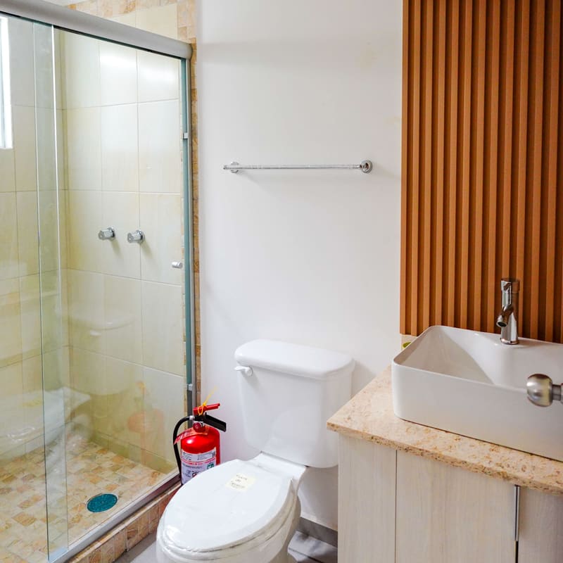 Baño completo con lavabo de sobreponer y cancel en departamento Borja