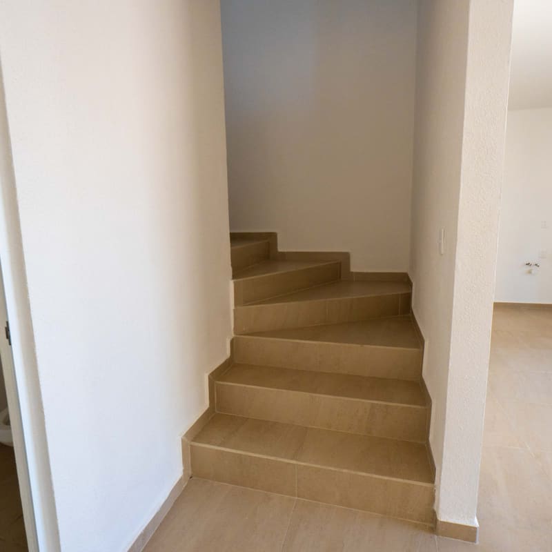 Escalera con barandal metálico en planta baja de modelo Castelo